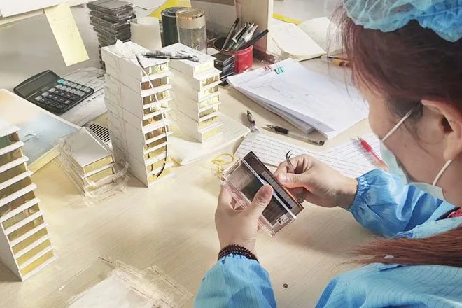 Lashestar worker inspecting eyelash trays during production